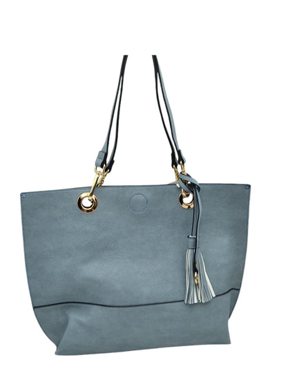 Gray handbag with gold accents and a tassel on a white background