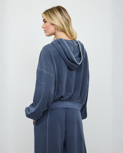 A woman wearing a matching navy blue loungewear set, shown from the back and side profile against a plain light gray background.