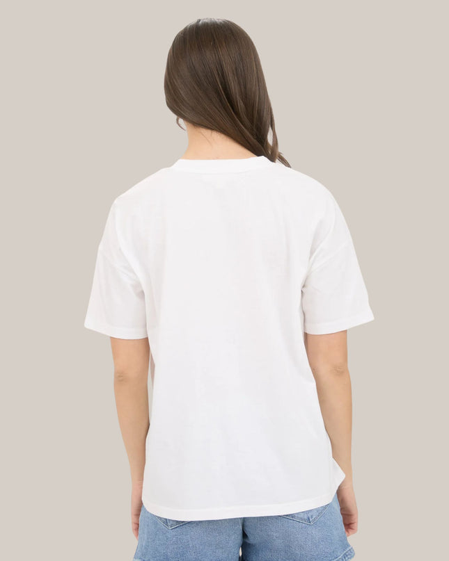 Person wearing a plain white t-shirt and blue jeans on a beige background