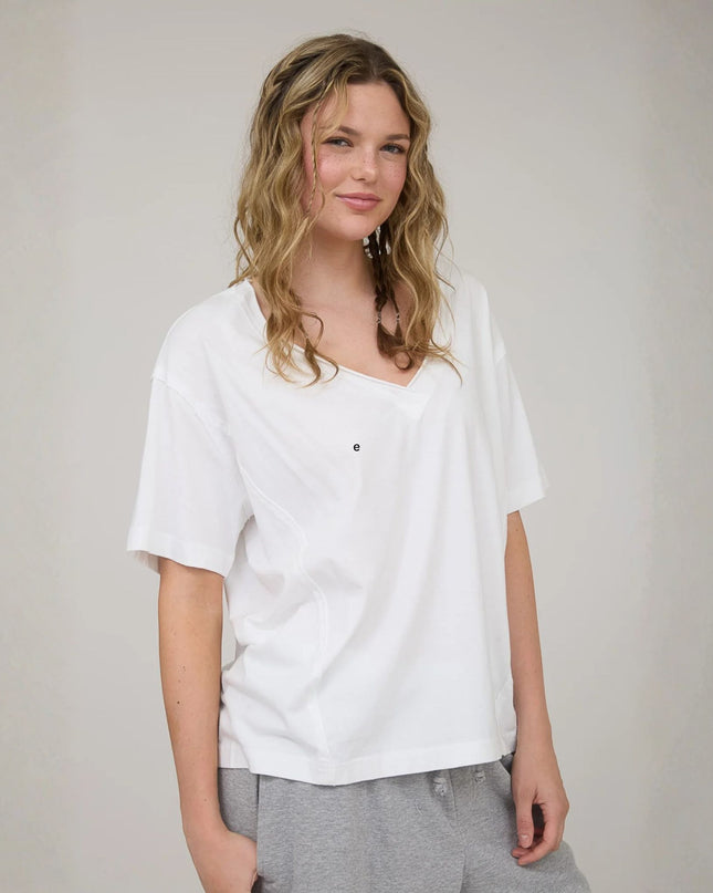 Woman wearing a white t-shirt against a plain background