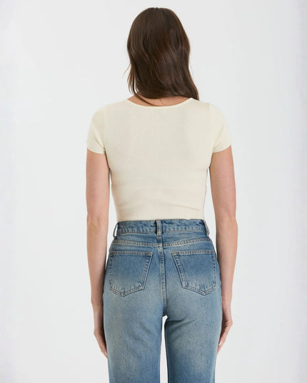 Person wearing a white t-shirt and blue jeans on a plain background
