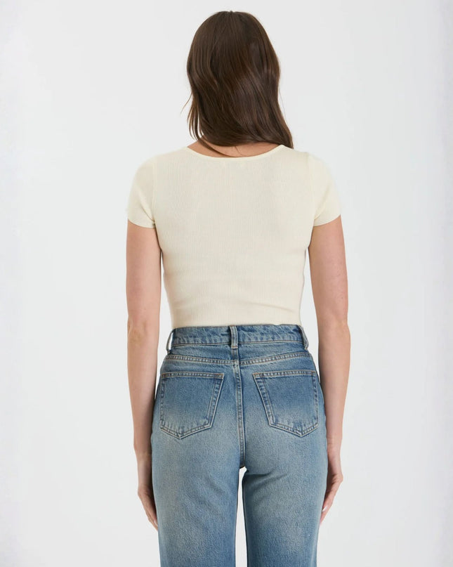 Person wearing a white t-shirt and blue jeans on a plain background