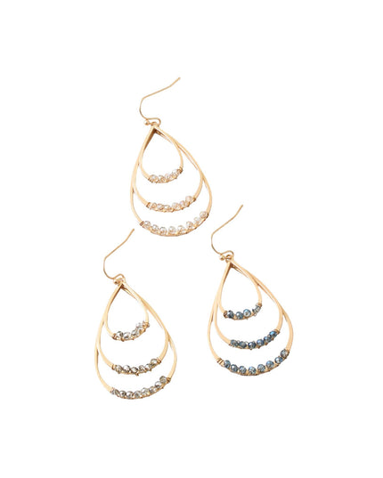 A pair of gold teardrop dangle earrings with three curved tiers, each accented with small round stones in silver, clear, and blue-gray tones, shown on a plain white background.