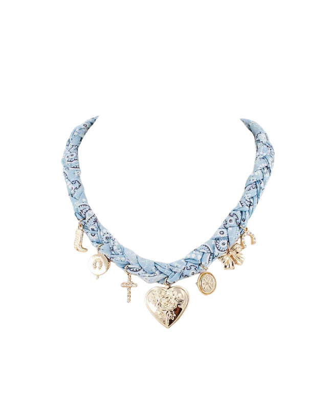 A light blue patterned fabric choker necklace with gold-toned charms, including a heart-shaped pendant, crescent moon, cross, and small decorative charms, shown on a plain white background.