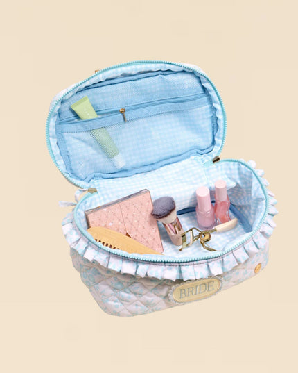 Open light blue jewelry box with items on a beige background