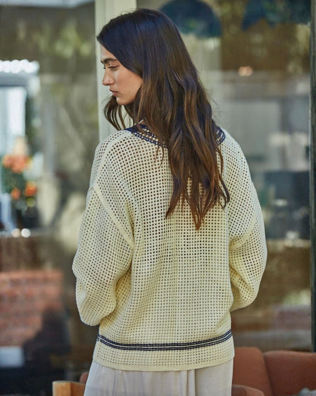 Woman wearing a light-colored knit cardigan in an outdoor setting
