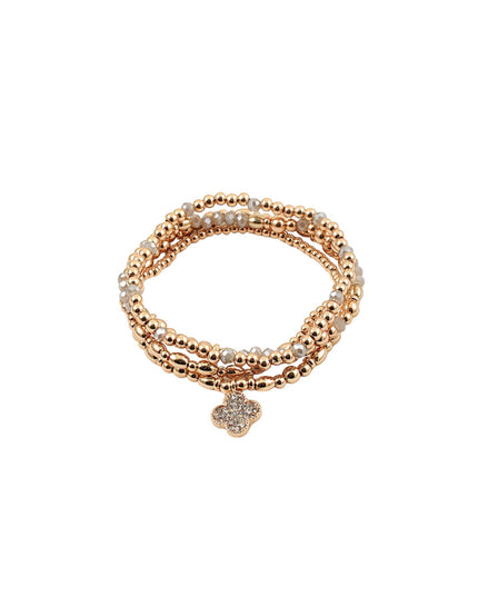 A multi-strand beaded stretch bracelet in rose gold with a small clover-shaped charm, photographed on a solid white background.