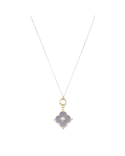 A delicate gold chain necklace featuring a four-petal flower pendant with lavender purple enamel and a small central clear stone, shown against a plain white background.