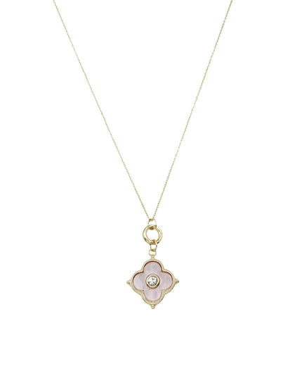 A delicate gold chain necklace featuring a four-petal flower pendant with a pale pink inlay and a small clear central stone, shown against a plain white background.