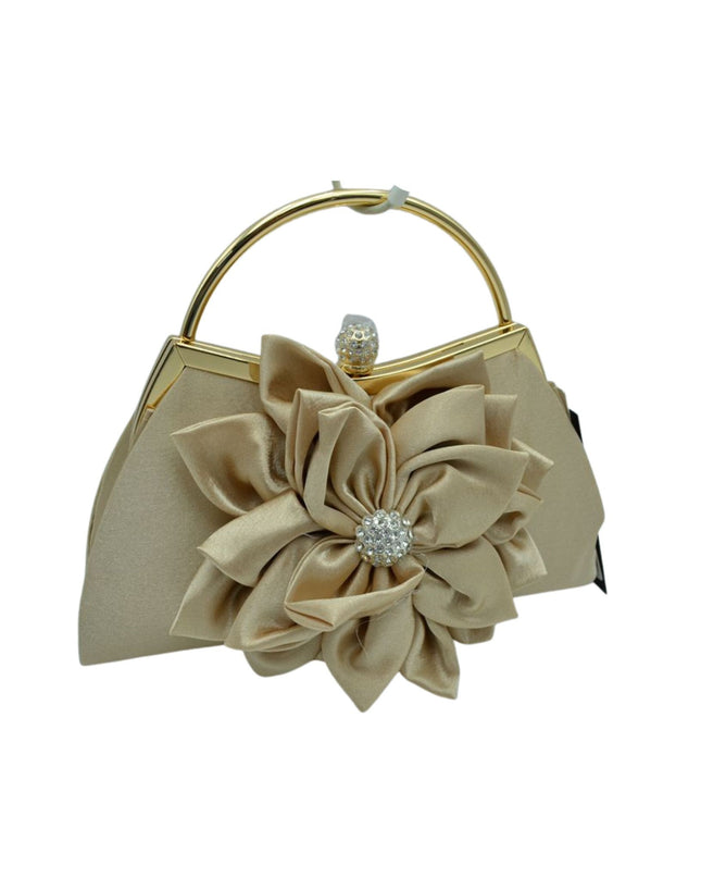 A champagne beige satin evening handbag with a large fabric flower applique on the front, a gold-tone metal top handle, and a rhinestone-embellished clasp.