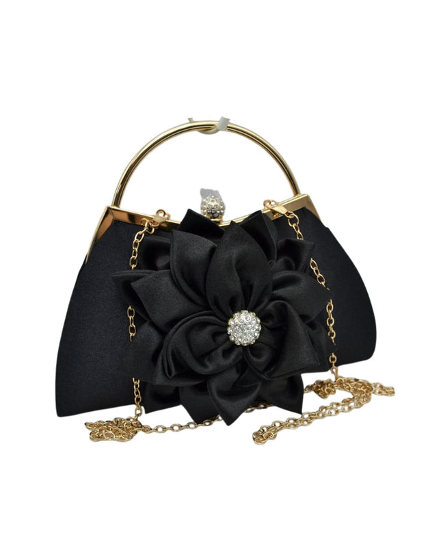 Black satin evening handbag with a large fabric flower embellishment, gold-tone metal frame, top handle, and chain strap on a white background.