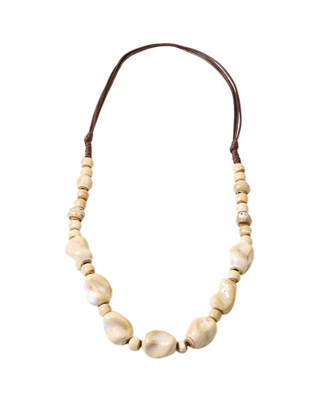 A beaded necklace featuring large, irregular cream-colored shell beads in the center, flanked by smaller round beads, with a dark brown adjustable cord at the top, shown on a plain white background.