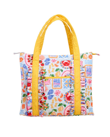 Colorful tote bag with floral pattern and yellow handles on a white background
