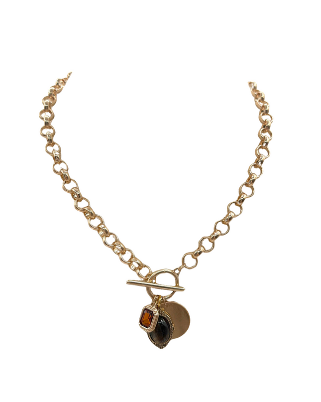 A gold-tone chain necklace with a toggle clasp and a small pendant featuring a square amber-orange stone and a dark oval stone, displayed on a clean white background.