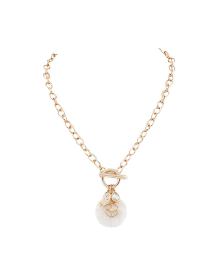 A delicate gold chain necklace with a toggle clasp and a dangling white round pendant featuring a small gold heart charm, set against a plain white background.