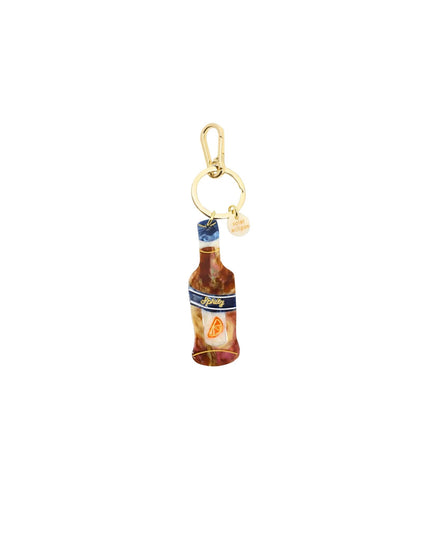 A miniature bottle charm with a gold-tone clasp and a small pearl bead, featuring a detailed label design.