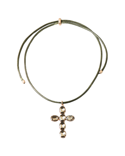 An olive green double-strand cord necklace with a small cross pendant adorned with faceted clear crystals, set against a plain white background.