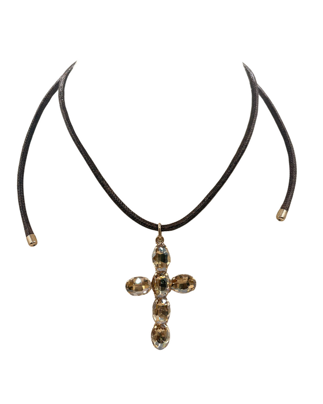 A dark brown leather choker necklace featuring a cross-shaped pendant adorned with faceted gold and smoky brown crystals, displayed against a solid white background.