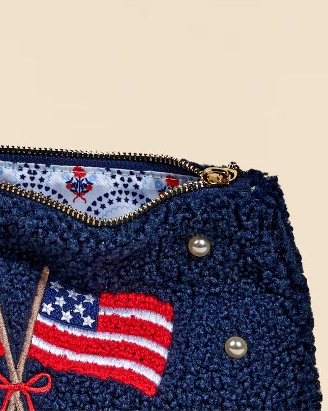 Navy blue pouch with American flag design and decorative elements on a beige background