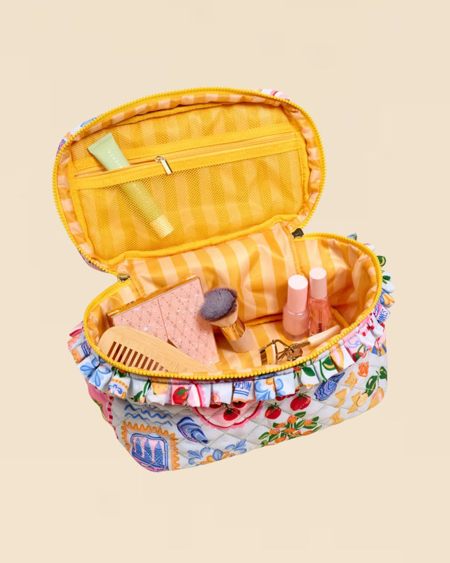 Open toy makeup case with various cosmetic items on a beige background