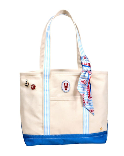 Beige tote bag with blue accents and a decorative scarf on a white background