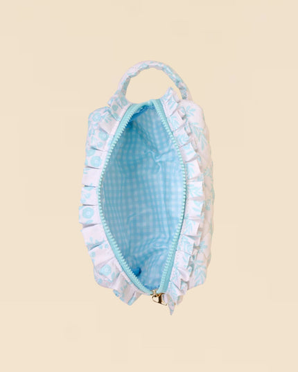 Light blue pouch with ruffled edges on a beige background