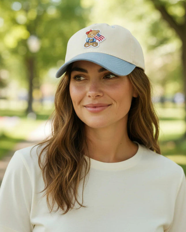 Woman wearing a cap with a teddy bear design in a park setting