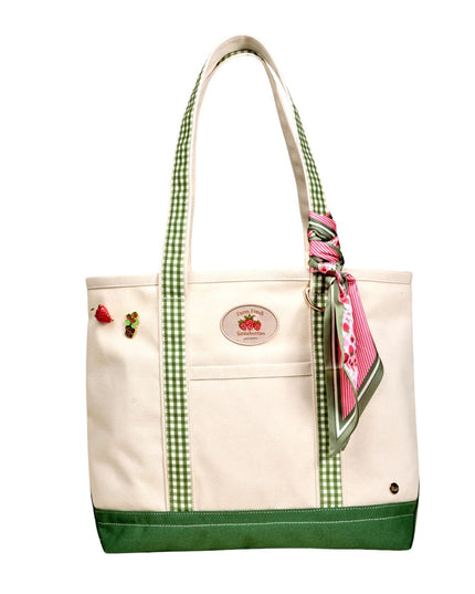 Beige tote bag with green accents and a pink scarf, on a white background