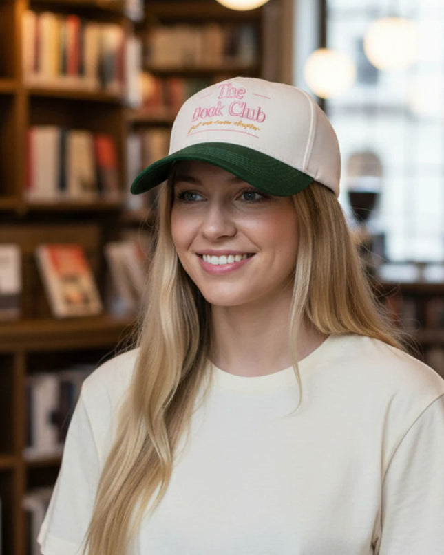 Woman wearing a 'Book Club' cap in a bookstore