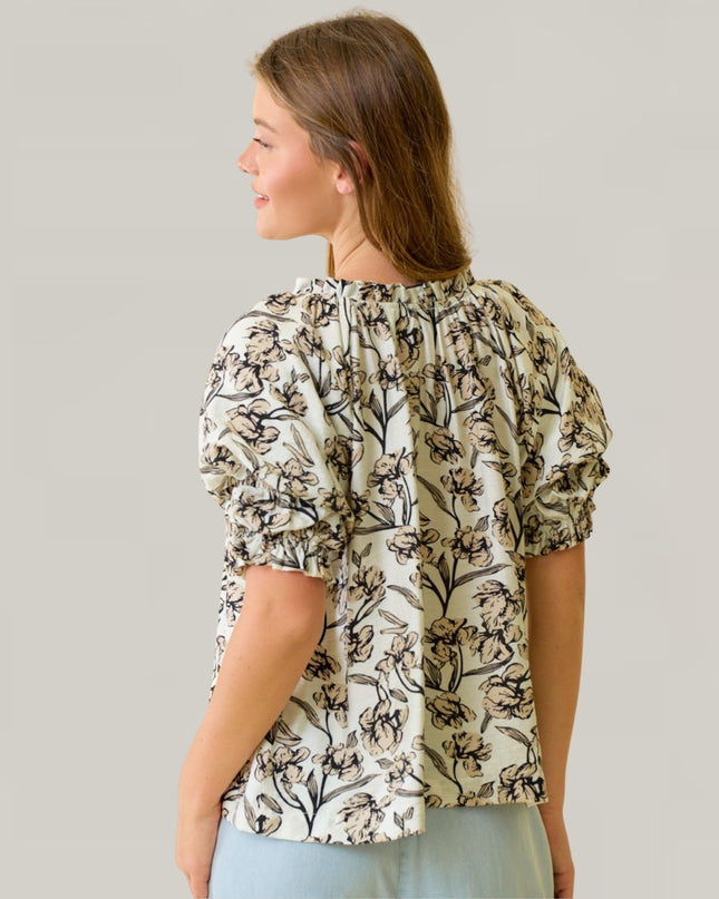 Woman wearing a floral blouse against a plain background
