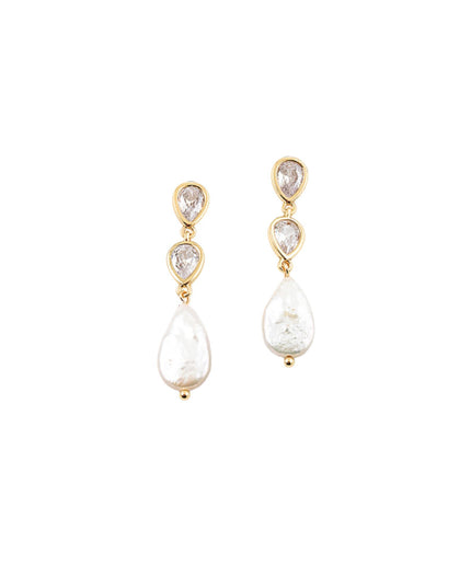 A pair of gold drop earrings featuring a small teardrop-shaped clear gemstone above a larger irregular white pearl drop, set against a plain white background.