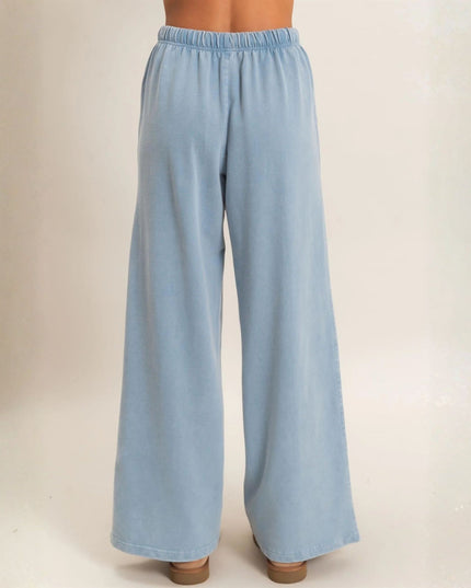 Light blue wide-leg pants with an elastic waistband, shown on a model from the back against a plain beige studio background.