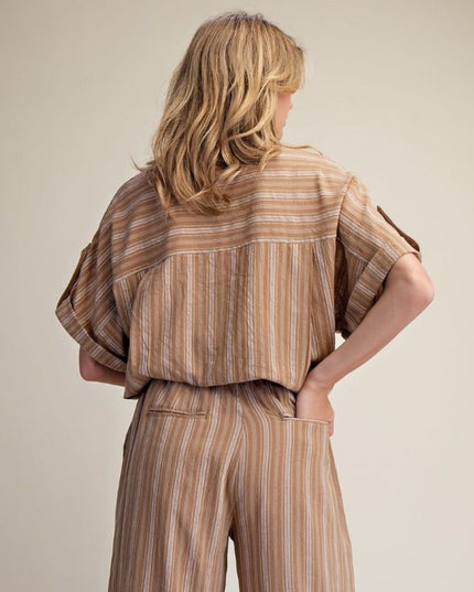 A woman shown from the back wearing a brown and beige vertically striped short-sleeve top and matching wide-leg pants against a plain beige studio background.