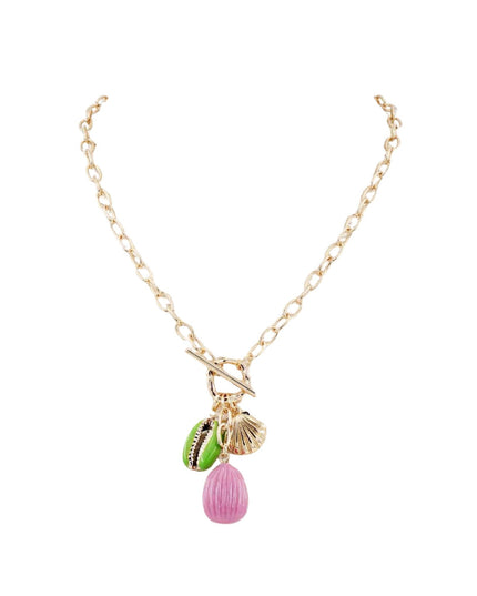 A gold chain necklace with a toggle clasp and three small charms: a green and black patterned bead, a gold seashell charm, and a pink teardrop bead.