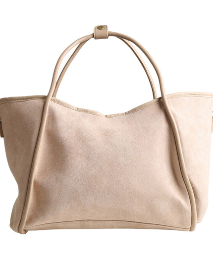 A light beige suede or faux-suede hobo tote bag with dual top handles and small gold-tone hardware, shown against a plain white background.