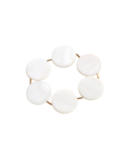 A stretch bracelet made of seven smooth, round white mother-of-pearl discs connected by small rose gold metal spacers, shown on a plain white background.