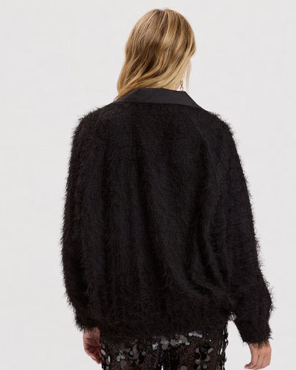 A model shown from the back wearing a black fuzzy, textured cardigan with a solid black collar, paired with black sequined pants, against a plain white studio background.
