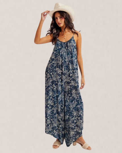 Woman wearing a blue floral dress and white hat on a light background