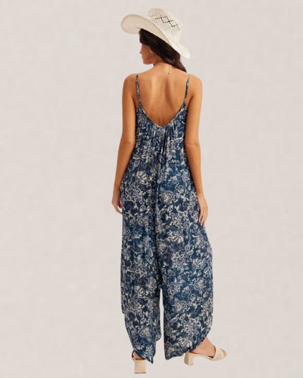 Woman wearing a blue floral jumpsuit on a plain background
