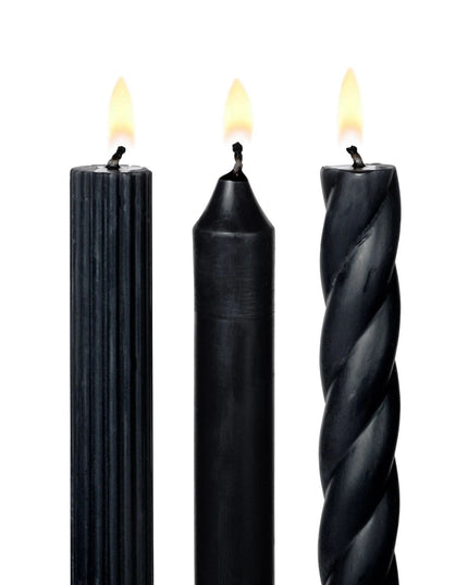 Three black candles with different textures on a white background