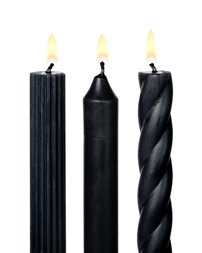 Three black candles with different textures on a white background