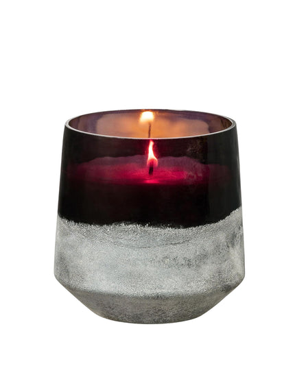 Candle in a decorative glass holder with a white background