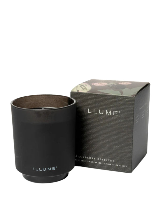 Black candle with 'ILLUME' branding next to its packaging on a white background