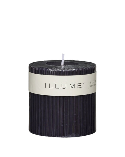 Black candle with 'ILLUME' label on a white background