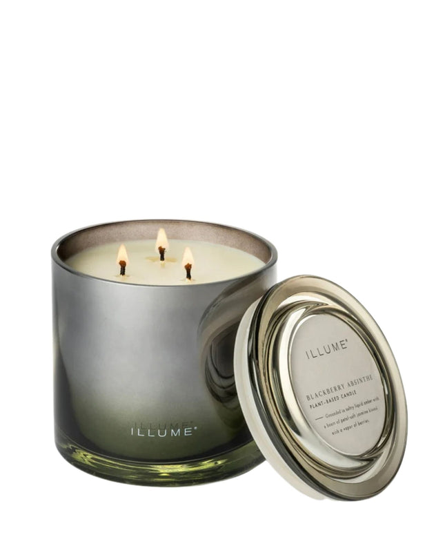 Illuminated candle in a glass container with a metallic lid on a white background