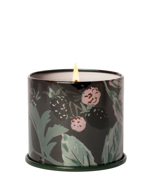 Candle in a decorative container with floral design on a white background