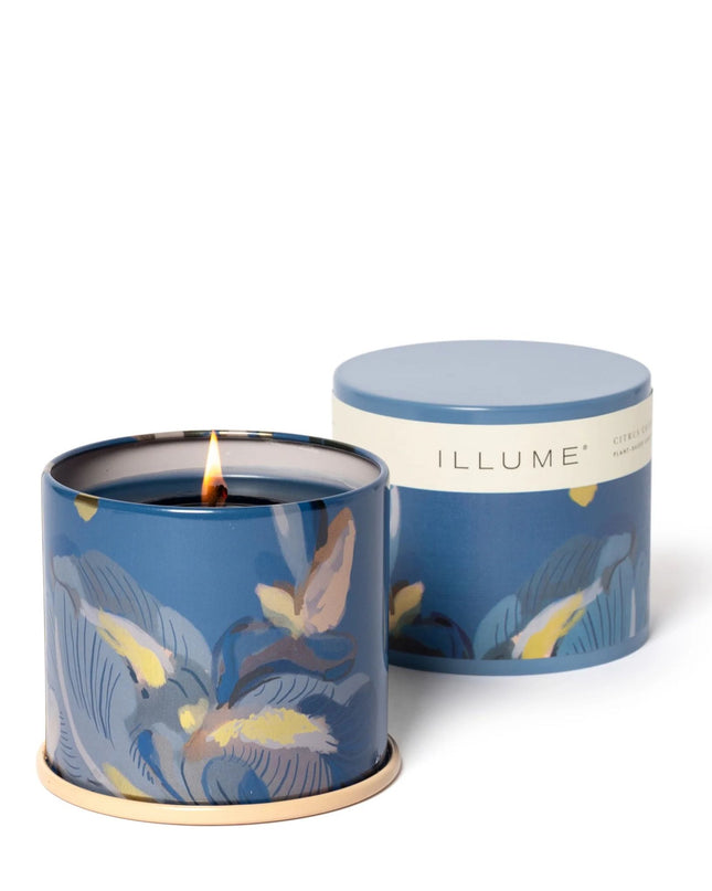 Blue candle with floral design and matching lid on a white background