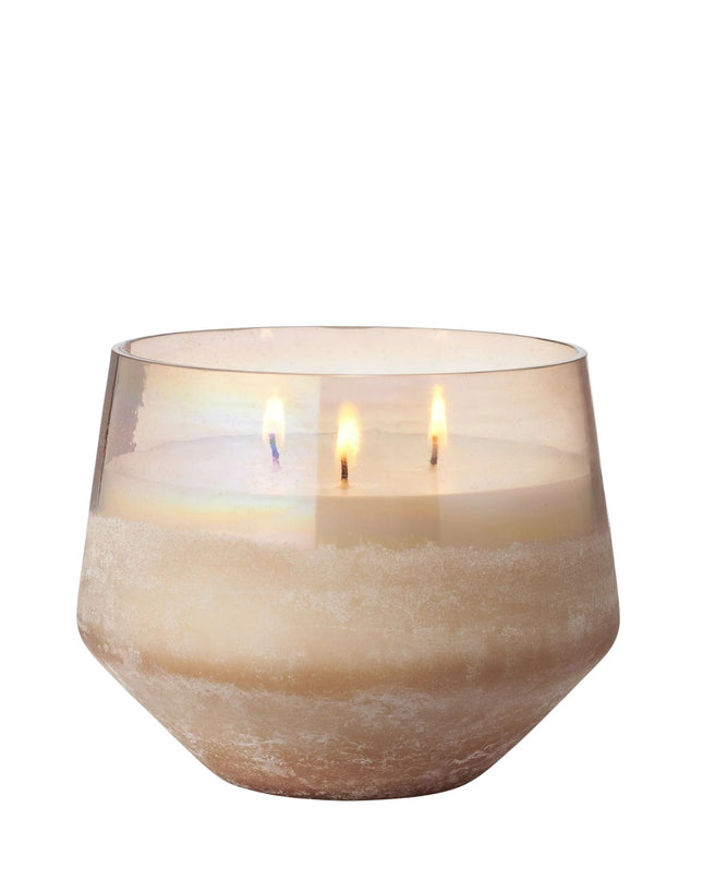 Candle in a textured glass holder on a white background