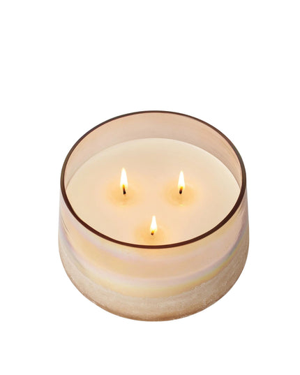 Three-wick candle in a glass container on a white background