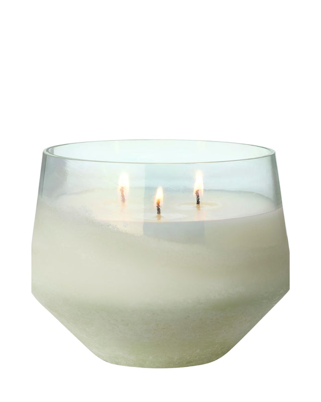 White candle in a glass holder on a white background